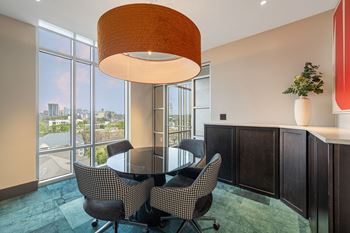 a dining area with a glass table and chairs and a large window
